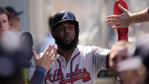 Atlanta Braves designated hitter Marcell Ozuna celebrates in the dugout after scoring off a sacrifice fly by Jarred Kelenic during the eighth inning of a baseball game against the Los Angeles Angels, Sunday, Aug. 18, 2024, in Anaheim, Calif. (AP Photo/Ryan Sun)