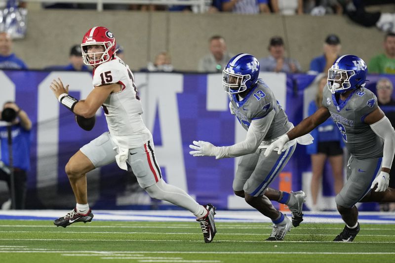 Georgia quarterback Carson Beck (15) is chased by Kentucky linebackers J.J. Weaver (13) and Jamon Dumas-Johnson (2) during the second half of an NCAA college football game, Saturday, Sept. 14, 2024, in Lexington, Ky. (AP Photo/Darron Cummings)