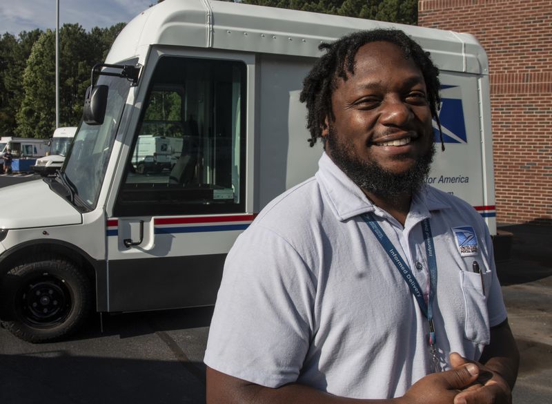 U.S. Postal Service delivery driver Richard Burton stands in the work lot of a postal facility on Thursday, Sept. 5, 2024, in Athens, Ga. (AP Photo/Ron Harris)