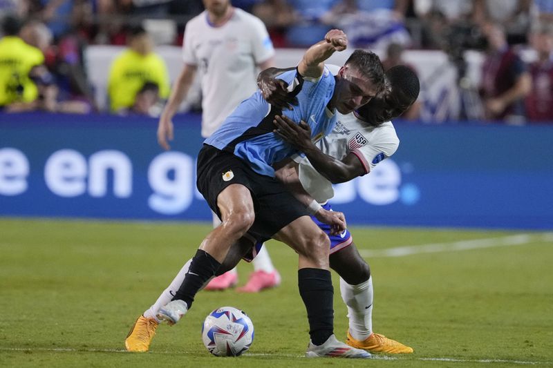 Uruguay's Rodrigo Bentancur, left, and Yunus Musah, right, of the United States, battle for the ball during a Copa America Group C soccer match, Monday, July 1, 2024, in Kansas City, Mo. (AP Photo/Ed Zurga)