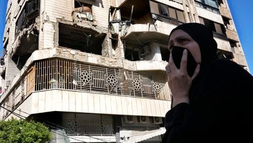 A woman reacts in front an apartment in a multistory building hit by Israeli airstrike, in central Beirut, Lebanon, Thursday, Oct. 3, 2024. (AP Photo/Hussein Malla)