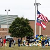 A electronic billboard showing 14-year-old Apalachee High School students Christian Angulo and Mason Schermerhorn, and teachers Cristina Irimie and Richard Aspinwall is seen at a vigil at Jug Tavern Park in Winder on Friday, Sept. 6, 2024. A 14-year-old Apalachee High School student is accused of shooting and killing the four and injuring nine others at the Barrow County high school on Wednesday. (Arvin Temkar/AJC)