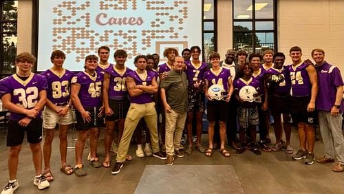 The Cartersville football team shows off the new helmet covers it will wear this season. The Purple Hurricanes are getting customized covers with the school logo to wear in practice and games.