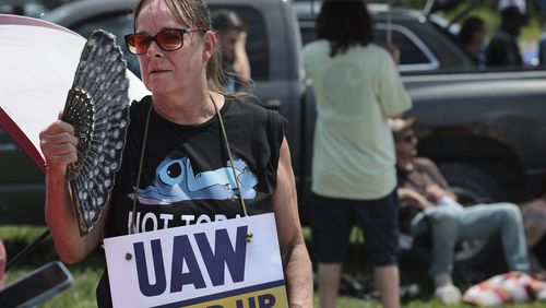 Assembly line worker Sheila Buckley tries to keep cool while on the picket line as members of United Auto Workers Local 282 are on strike against Lear, a car and truck seat manufacturer in Wentzville, Mo. on Tuesday, July 23, 2024. The strike led to a shutdown at the nearby GM assembly plant. (Robert Cohen/St. Louis Post-Dispatch via AP)