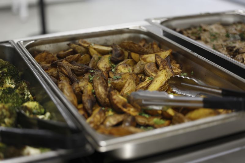 The United States Olympic and Paralympic Committee's High Performance Center offers Chili Spiced Potato Wedges to athletes during the Paralympic Games in Paris on Saturday, Aug. 31, 2024. Above the food are placards that tell the athletes what the food is, a serving size, the nutrition facts and allergens present in the food. (AP Photo/Nathalee Simoneau)