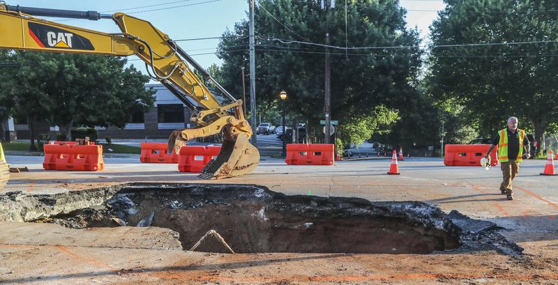 June 28, 2023 Atlanta: A day after a massive sinkhole opened along one of Midtown Atlanta's busiest roads, swallowing an SUV, traffic resumed on Wednesday, June 28, 2023. Crews were still digging up dirt and temporary road blocks remain in place on Ponce de Leon Avenue, but at least one eastbound lane and two westbound lanes are open.  The portion of road between Myrtle Street and Argonne Avenue had been closed to traffic since Tuesday afternoon to repair a broken sewer pipe that caused the surface to collapse.  Officials with the city's Watershed Management Department described the culprit as a 