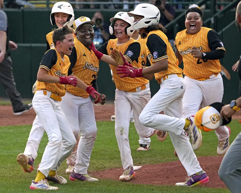 Lake Mary, Fla.'s Hunter Alexander, left front, celebrates with teammates after laying down a game-winning, walk-off bunt in the eighth inning of the Little League World Series Championship game against Taiwan in South Williamsport, Pa., Sunday, Aug. 25, 2024. (AP Photo/Gene J. Puskar)