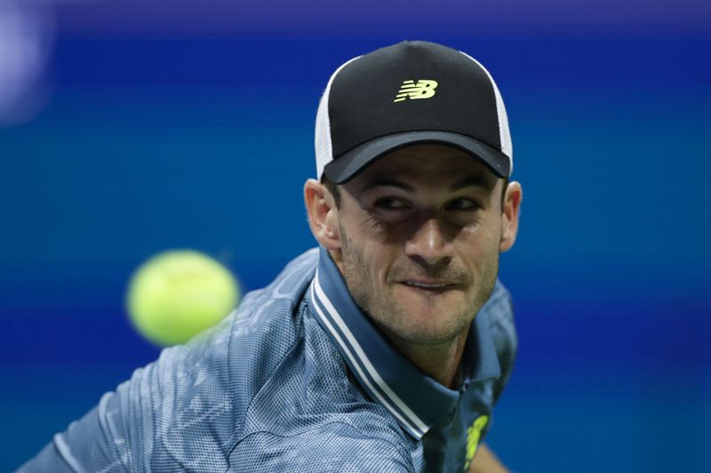 Tommy Paul, of the United States, returns a shot to Jannik Sinner, of Italy, during a fourth round match of the U.S. Open tennis championships, Monday, Sept. 2, 2024, in New York. (AP Photo/Adam Hunger)