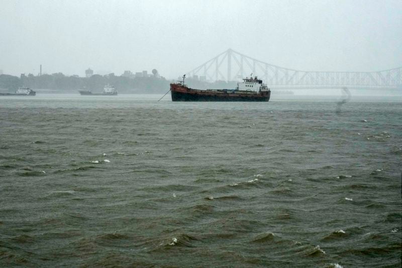 A vessel stands in the Hooghly River in the backdrop of Hooghly Bridge in Kolkata, India, as rain continues after cyclone Remal made a landfall near Bangladesh-India border, Monday, May 27, 2024. (AP Photo/Bikas Das)