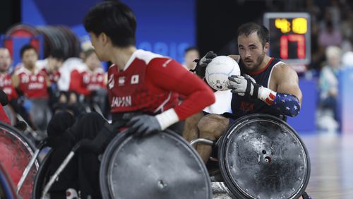 Chuck Aoki from the U.S. carries the ball during the U.S. vs Japan wheelchair rugby preliminary match during the Paralympic Games in Paris on Friday, Aug. 30, 2024. The U.S. Olympic and Paralympic Committee has launched a new project titled “Team USA Creators” to capture behind-the-scenes content at the Paralympics. Ten total athletes and influencers were selected to attend the event, have fun and raise disability visibility. Wheelchair rugby player Chuck Aoki is the only athlete competing and creating at these games. (AP Photo/Avni Trivedi)