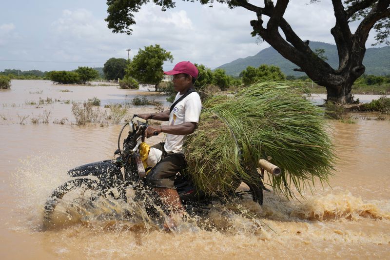 A local resident drives a motorbike along a flooded road in Naypyitaw, Myanmar, Sunday, Sept. 15, 2024. (AP Photo/Aung Shine Oo)