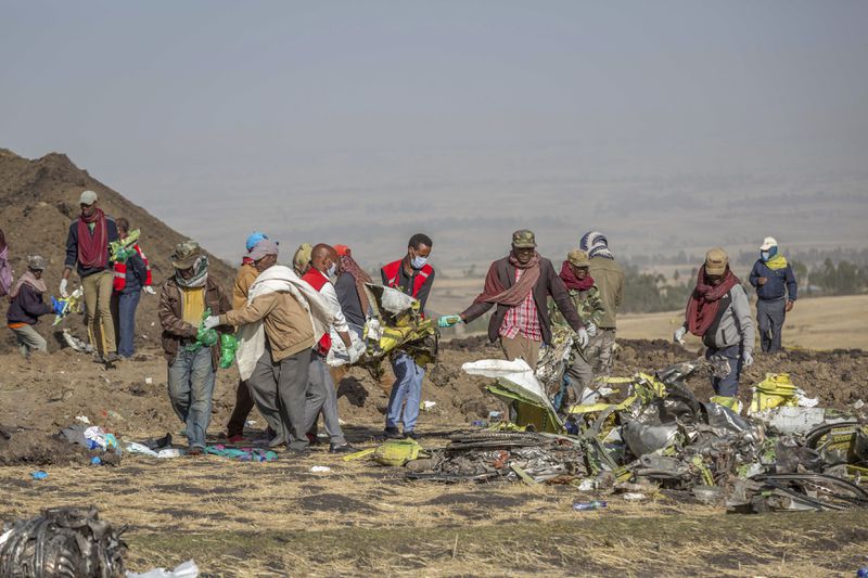 FILE - Rescuers work at the scene of an Ethiopian Airlines Boeing Max crash near Bishoftu, or Debre Zeit, south of Addis Ababa, Ethiopia, on March 11, 2019. Ike Riffel , a California father whose two sons, died in the crash, fears that instead of putting Boeing on trial, the government will offer the company another shot at corporate probation through a legal document called a deferred prosecution agreement, or DPA. (AP Photo/Mulugeta Ayene, File)