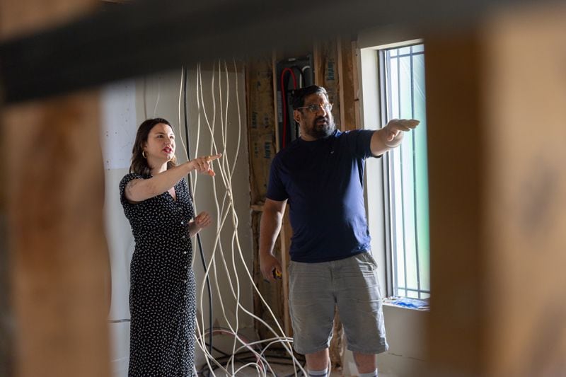 Grace Smith speaks to carpenter Mayur Deshmukh in the building that will house Smith and her husband’s new  bookstore in Chamblee on May 31, 2024. (Arvin Temkar / AJC)