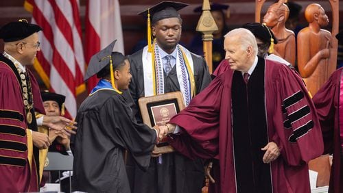 President Biden shakes hands with salutatorian Dwayne Allen Terrell II, left, at the commencement ceremony on May 19 at Morehouse College in Atlanta. (Arvin Temkar/The Atlanta Journal-Constitution)