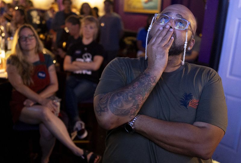 Jocardo Ralston, 47, from Pennsylvania, reacts as they look up to a television to watch the presidential debate between President Joe Biden and Republican presidential candidate former President Donald Trump at Tillie's Lounge on Thursday, June 27, 2024, in Cincinnati. "Biden has my vote because there is nothing at this point that Trump can say," said Ralston. For many voters in the U.S., there's despair in the air after the presidential debate this past week. (AP Photo/Carolyn Kaster)