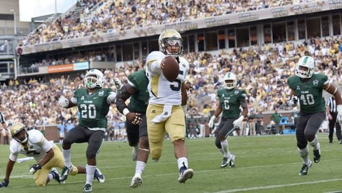 Georgia Tech Yellow Jackets quarterback Justin Thomas (5) holds a ball as he scores a touchdown against the Tulane Green Wave in the first half at Bobby Dodd Stadium on Saturday, September 12, 2015. HYOSUB SHIN / HSHIN@AJC.COM