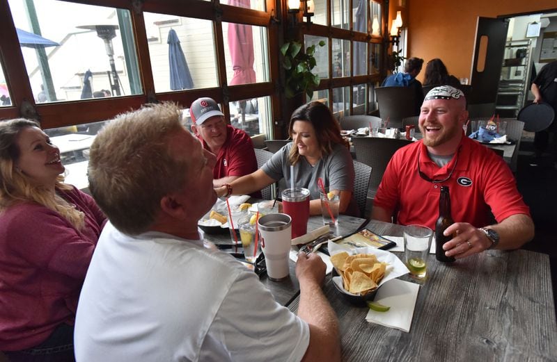  Trent Woods crossed enemy lines to break bread with Sooners fans Kelli Clark and Charlie Salsman, both of Edmond, Okla., and Brent Byrd and Shawna Byrd, both of Lawton, Okla. ahead of the 2018 Rose Bowl. AJC photo: Hyosub Shin