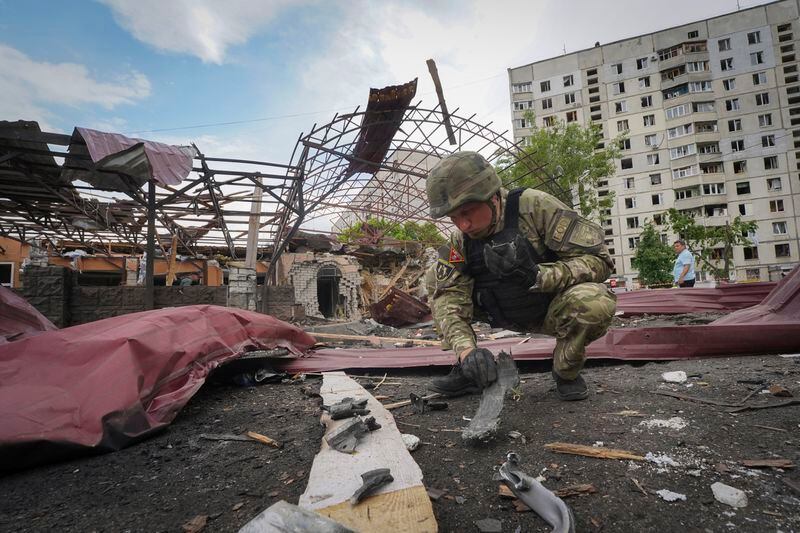 A sapper inspects fragments of a Russian air bomb that hit a living area injuring ten in Kharkiv, Ukraine, Wednesday, May 22, 2024. (AP Photo/Andrii Marienko)