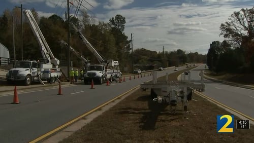 Crews work on the power pole that a 17-year-old Forsyth County high school student crashed into Tuesday morning, killing her 16-year-old passenger, authorities said.