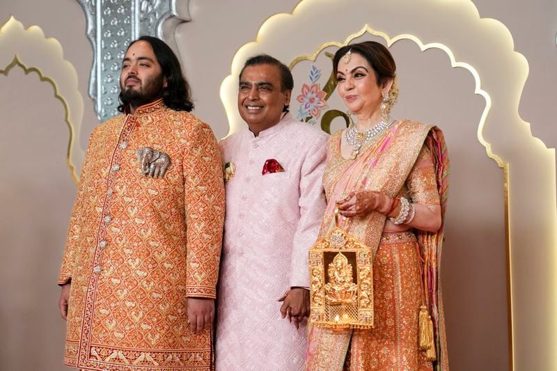 Billionaire Mukesh Ambani, center, poses with son Anant, and wife Neeta at Anant Ambani and Radhika Merchant's wedding at Jio World Convention Centre in Mumbai, India, Friday, July 12, 2024. (AP Photo /Rajanish Kakade)