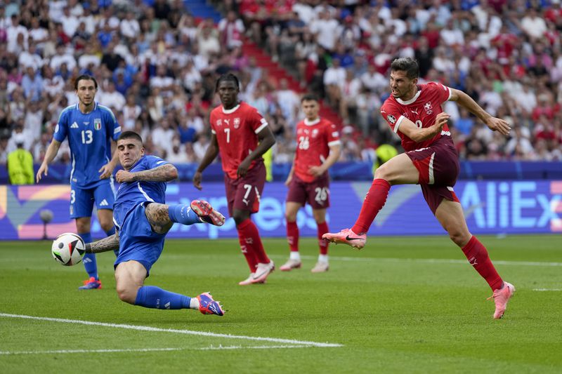 Switzerland's Remo Freuler, right, shoots and scores past Italy's Gianluca Mancini during a round of sixteen match between Switzerland and Italy at the Euro 2024 soccer tournament in Berlin, Germany, Saturday, June 29, 2024. (AP Photo/Matthias Schrader)
