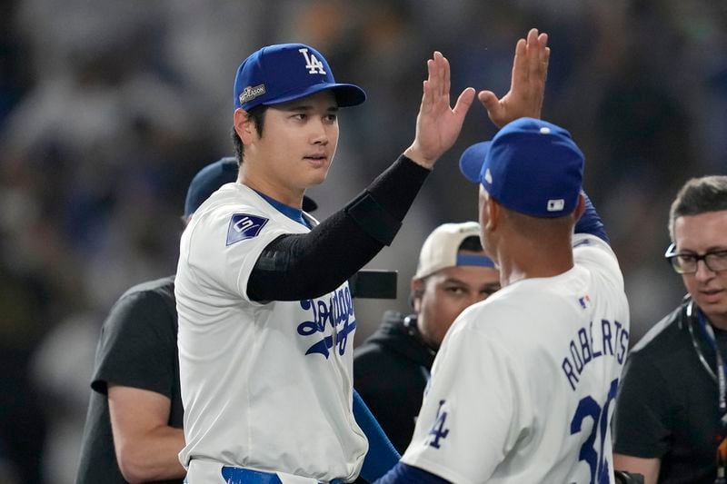 Los Angeles Dodgers' Shohei Ohtani, left, celebrates with manager Dave Roberts after the Dodgers defeated the San Diego Padres in Game 1 of baseball's NL Division Series, Saturday, Oct. 5, 2024, in Los Angeles. (AP Photo/Ashley Landis)