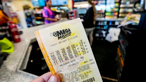 FILE - A Mega Millions ticket is seen as a person makes a purchase inside a convenience store, Aug. 7, 2023, in Kennesaw, Ga. (AP Photo/Mike Stewart, File)