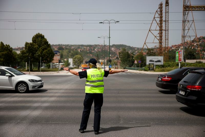 A police officer gestures towards cars as she tries to control traffic during a power outage in Sarajevo, Bosnia, Friday, June 21, 2024.(AP Photo/Armin Durgut)