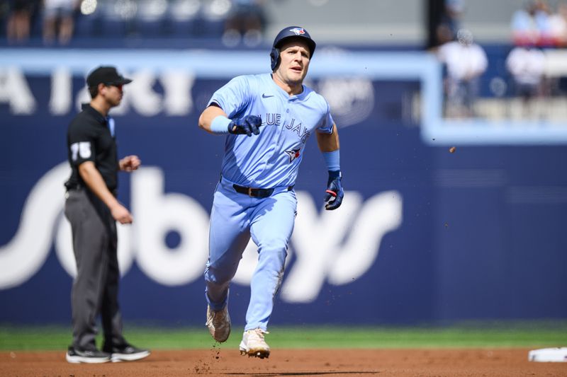 Toronto Blue Jays' Daulton Varsho, right, reaches third base on a throwing error by Los Angeles Angels pitcher Carson Fulmer to first baseman Niko Kavada during first-inning baseball game action in Toronto, Saturday, Aug. 24, 2024. (Christopher Katsarov/The Canadian Press via AP)