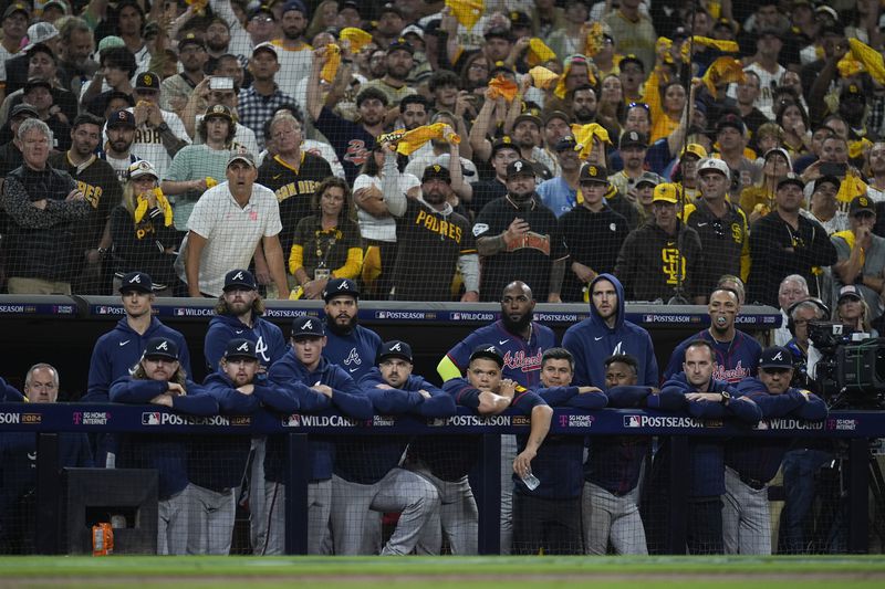 Members to the Atlanta Braves watch from the dugout during the ninth inning in Game 2 of an NL Wild Card Series baseball game against the San Diego Padres, Wednesday, Oct. 2, 2024, in San Diego. (AP Photo/Gregory Bull)