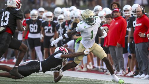 Buford running back Ethan Ervin (1) runs against Milton defensive back Dylan Lewis (0) during the first half at Milton High School, Friday, August 16, 2024, in Milton, Ga. (Jason Getz / AJC)
