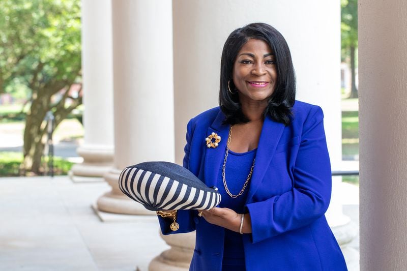 Dr. Angela Farris holds one of Alberta King's hats at Spelman College's Sisters Chapel. The youngest of Alberta's 11 grandchildren, Farris was 10 years old on the day of Alberta's assassination and had an exchange with her grandmother just minutes before her death. (Jenni Girtman for The Atlanta Journal-Constitution)