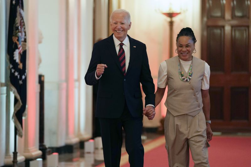 President Joe Biden walks with Dawn Staley, Coach of the University of South Carolina Women's basketball team, for an event in the East Room of the White House in Washington, Tuesday, Sept. 10, 2024, to welcome the University of South Carolina Gamecocks Women's basketball team and celebrate their 2023-2024 NCAA championship season. (AP Photo/Susan Walsh)