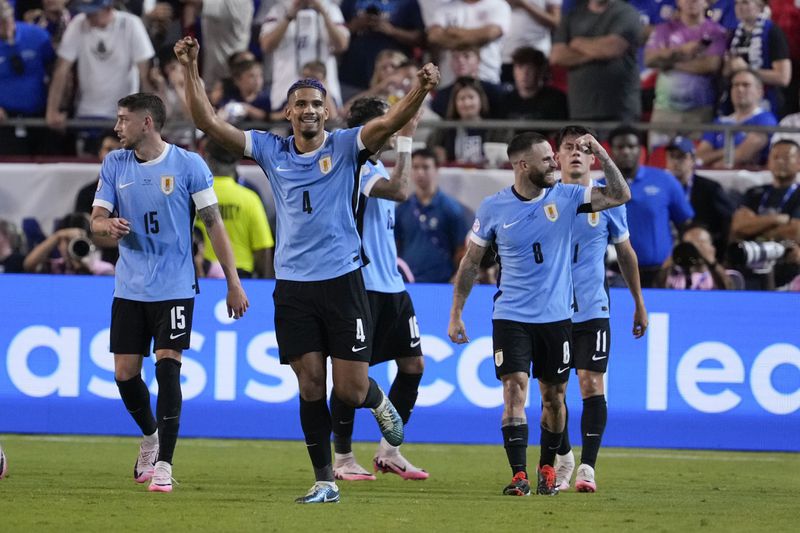 Uruguay's Ronald Araujo (4) celebrates after a goal by Mathias Olivera during a Copa America Group C soccer match against the United States, Monday, July 1, 2024, in Kansas City, Mo. (AP Photo/Ed Zurga)