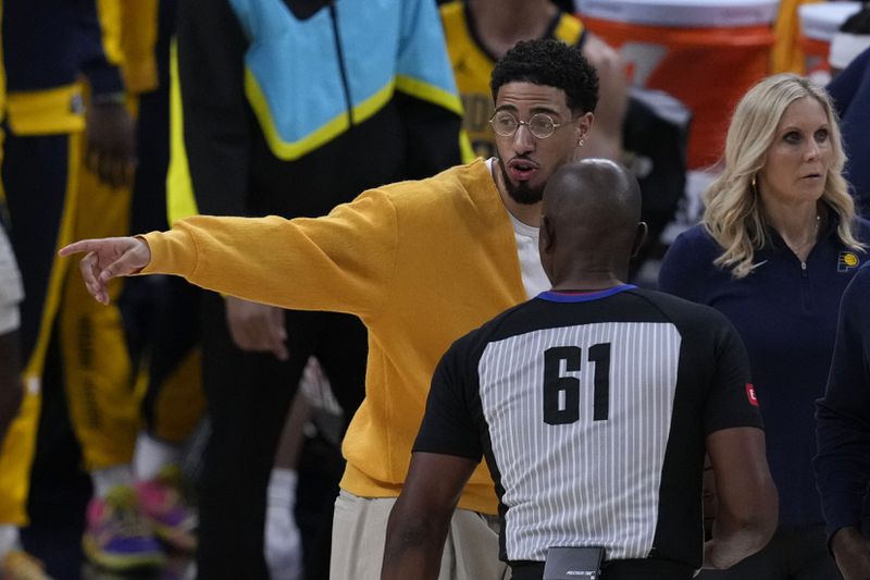 Injured Indiana Pacers guard Tyrese Haliburton talks with referee Courtney Kirkland (61) during the first half of Game 3 of the NBA Eastern Conference basketball finals against the Boston Celtics, Saturday, May 25, 2024, in Indianapolis. (AP Photo/Darron Cummings)