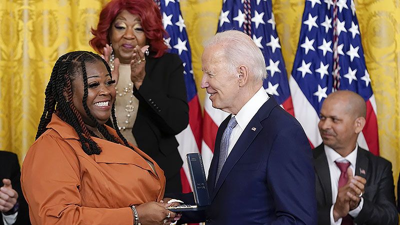 Ruby Freeman stands and applauds as President Joe Biden awards the Presidential Citizens Medal, the nation's second-highest civilian honor, to her daughter Shaye Moss, a former Georgia election worker, during a ceremony to mark the second anniversary of the Jan. 6 assault on the Capitol in the East Room of the White House in Washington, Friday, Jan. 6, 2023. (Patrick Semansky/AP)