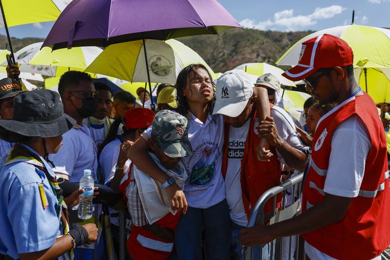 Medical workers carry a person as Catholic faithful gather to attend a Holy Mass that will be presided by Pope Francis at the Esplanade of Taci Tolu in Dili, East Timor, Tuesday, Sept.10, 2024. (Willy Kurniawan/Pool Photo via AP)