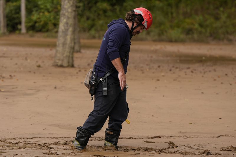 FILE - A fireman walks through mud as they search for victims of flash flooding in the aftermath of Hurricane Helene, Oct. 1, 2024, in Swannanoa, N.C. (AP Photo/Mike Stewart, File)