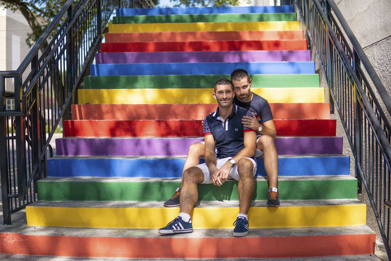 Stefan Arestis, left, with Sebastien Chaneac appear on rainbow-painted stairs in Tampa, Fla., in 2019. Together, the two write the travel blog The Nomadic Boys. (The Nomadic Boys via AP)