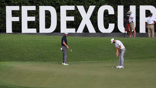 Dustin Johnson (right) and Jon Rahm (left) putt on the 11th green during the second round of the Tour Championship Saturday, Sept. 2, 2020, at East Lake Golf Club in Atlanta. (Curtis Compton / Curtis.Compton@ajc.com)