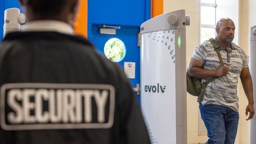 Commander Craig Blakely with the DeKalb schools police force, in plain clothes, walks through the new Evolv Express weapons detection system during a demonstration at Columbia High School in Decatur on Thursday, Aug. 3, 2023. (Arvin Temkar / arvin.temkar@ajc.com)