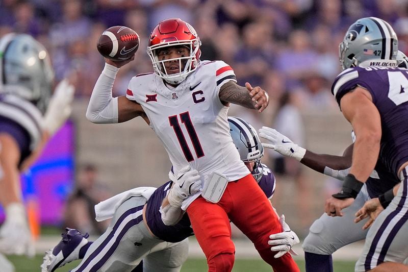 Arizona quarterback Noah Fifita (11) looks to pass under pressure from Kansas State linebacker Austin Moore (41) during the first half of an NCAA college football game Friday, Sept. 13, 2024, in Manhattan, Kan. (AP Photo/Charlie Riedel)