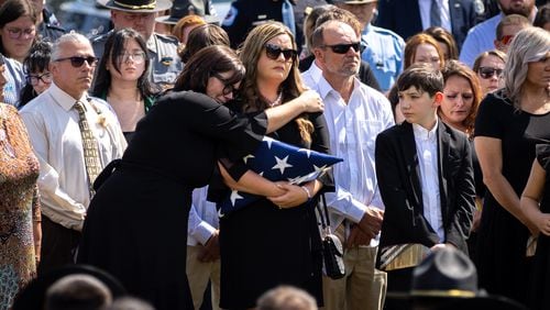 Melissa Bristow (center), the wife of Carroll County Investigator Taylor Bristow, is comforted at Mount Holly Church in Carrollton on Thursday, August 29, 2024, following the deputy’s funeral. Taylor Bristow was shot while serving a warrant and died from his injuries. (Arvin Temkar / AJC)