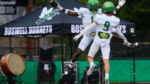 Ethan Ervin and Sam Harkness celebrate a Buford touchdown against host Roswell on September 6, 2024. Buford cruised 52-17. (Jamie Spaar for the Atlanta Journal Constitution)