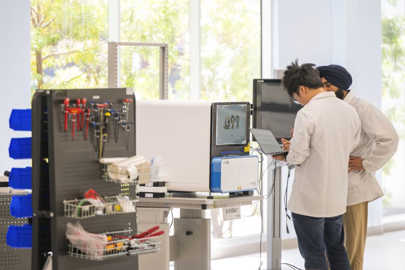 Technicians work inside the sequence instrument manufacturing department at Complete Genomics in San Jose, Calif., Monday, July 22, 2024. (AP Photo/Nic Coury)