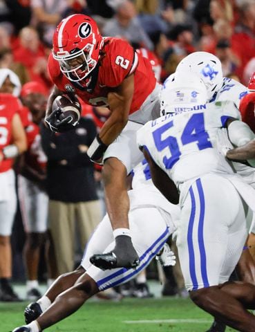 Georgia Bulldogs running back Kendall Milton (2) goes over the top of defenders for a seven yard gain during the second half of an NCAA football game between Kentucky and Georgia in Athens on Saturday, Oct. 7, 2023.   Georgia won 51 - 13.  (Bob Andres for the Atlanta Journal Constitution)