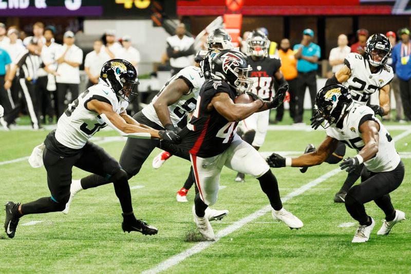 Atlanta Falcons' running back Caleb Huntley (42) rushes between Jaguars defenders during the fourth quarter of an NFL exhibition game against the Jacksonville, Jaguars on Saturday, August 27, 2022, at the Mercedes-Benz Stadium in Atlanta, Ga.
 Miguel Martinez / miguel.martinezjimenez@ajc.com