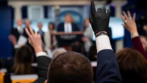 Reporters raise their hands to ask President Donald Trump questions during a press briefing with the coronavirus task force, at the White House, Monday, March 16, 2020, in Washington. (AP Photo/Evan Vucci)