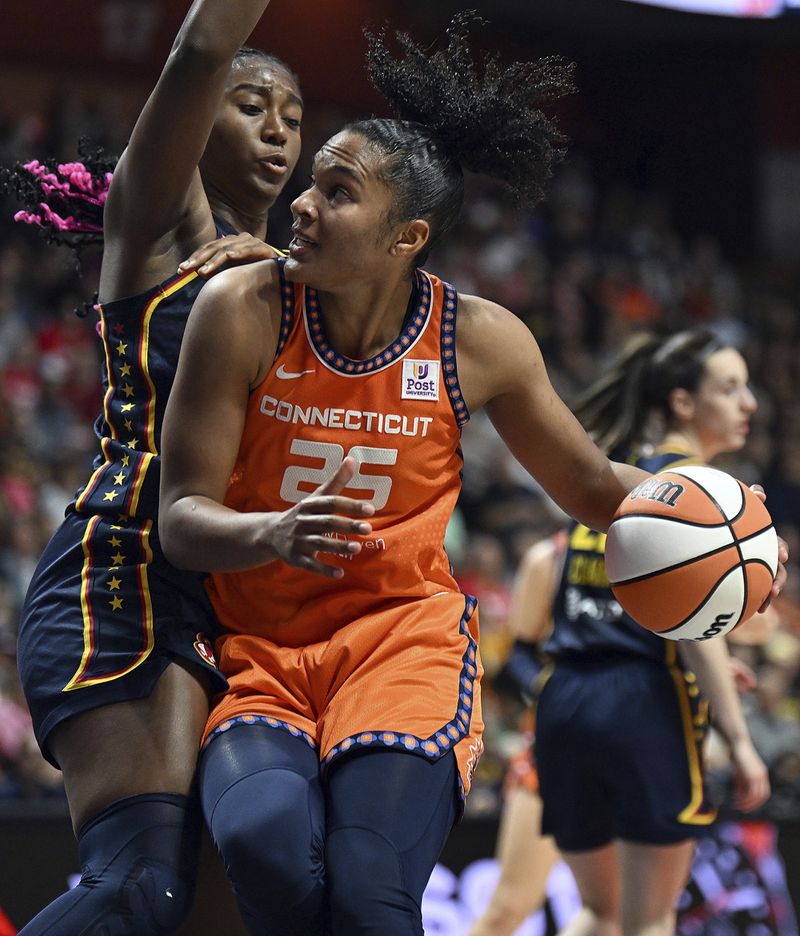 Connecticut Sun's Alyssa Thomas (25) attempts to move past Indiana Fever's Aliyah Boston, left, at the net during a first-round WNBA basketball playoff game at Mohegan Sun Arena, Sunday, Sept. 22, 2024. (Sarah Gordon/The Day via AP)