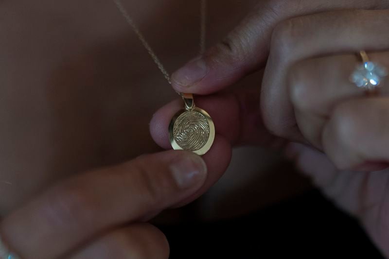 Mikayla Brown shows a pendant etched with the fingerprint of her son, Elijah Ott, who died of a fentanyl overdose at 15, in Atascadero, Calif., Friday, Aug. 2, 2024. (AP Photo/Jae C. Hong)